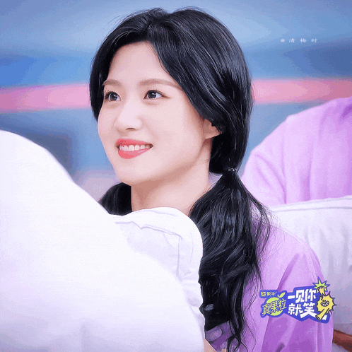 a woman in a purple shirt with chinese writing on it smiles