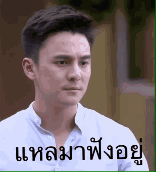 a man in a white shirt has a foreign language sticker on his face