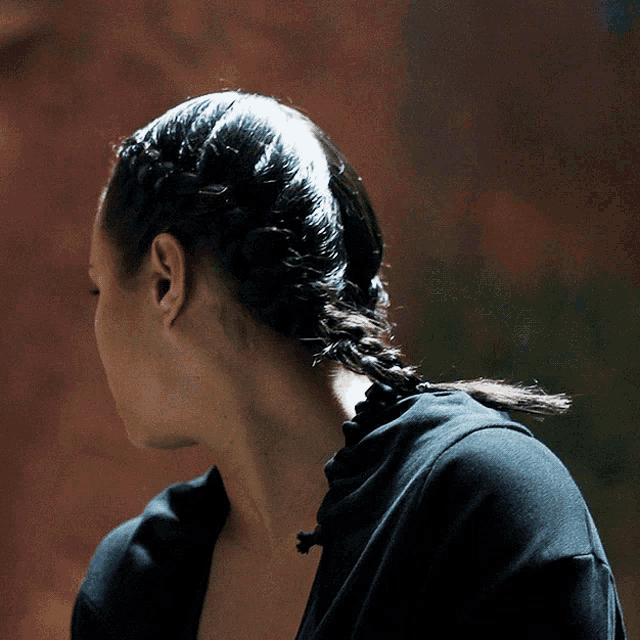 a woman with braids in her hair is wearing a black hoodie