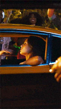 a man with a beard is driving a car and looking out the window