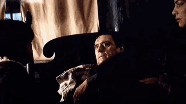 a man is sitting in a chair talking to a woman .
