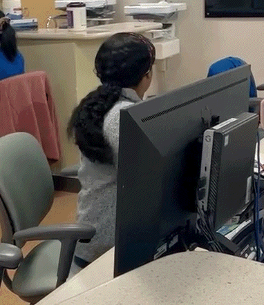 a woman is sitting in a chair in front of a computer monitor .