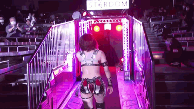 a female wrestler is walking through a tunnel with a sign that says stardom