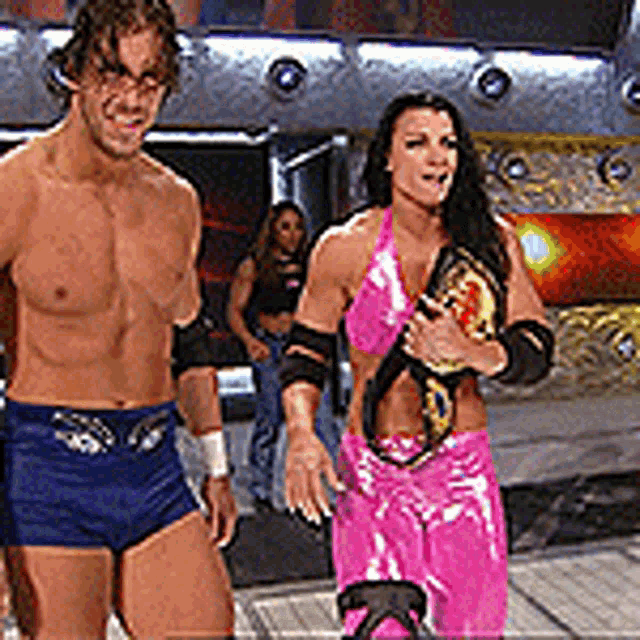 a man and a woman are standing on a wrestling ring .