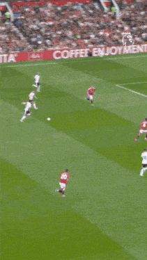 a soccer player is running on the field in front of a crowd and a sign that says ' premier league ' on it