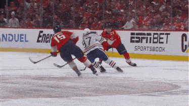 a hockey game is being played in front of an espn bet sportsbook ad