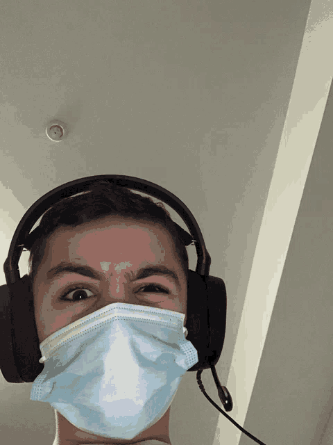 a man wearing a mask and headphones is making a funny face