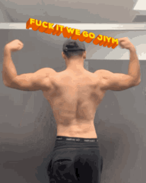 a shirtless man flexes his muscles in front of a sign that says " fuck it we go gym "