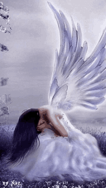 a woman in a white dress with angel wings is kneeling down