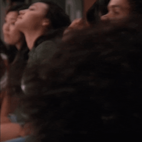 a group of people are sitting in a dark room and one of them is looking up