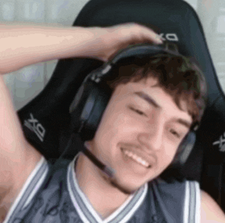 a young man wearing headphones and a microphone is sitting in a chair .