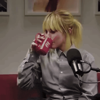a woman is drinking from a red mug that says supreme
