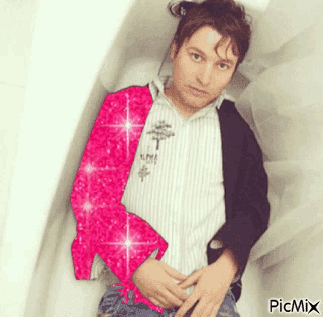 a picture of a man laying in a bathtub with a picture of a pink dolphin on his shirt