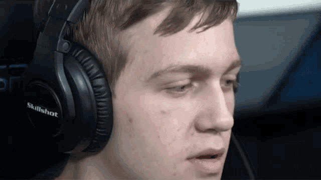 a man wearing a pair of skillshot headphones looks at the camera