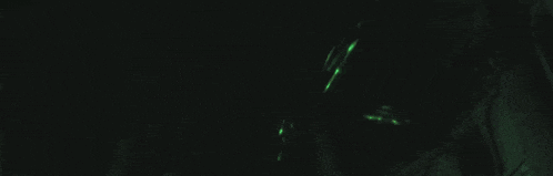 a dark room with a green light coming out of the ceiling