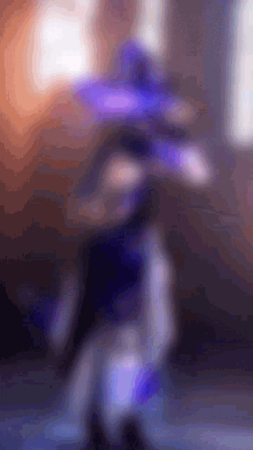 a blurred image of a person with a purple hat