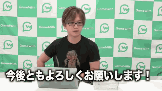 a man sitting in front of a wall with game with written on it