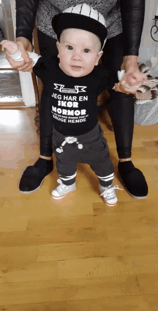 a baby with a shirt that says jeg har en sko mormor