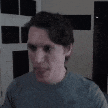 a man in a blue shirt is making a face