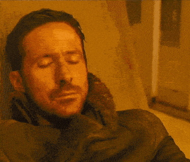 a man with a beard is sitting in a chair and looking at the camera