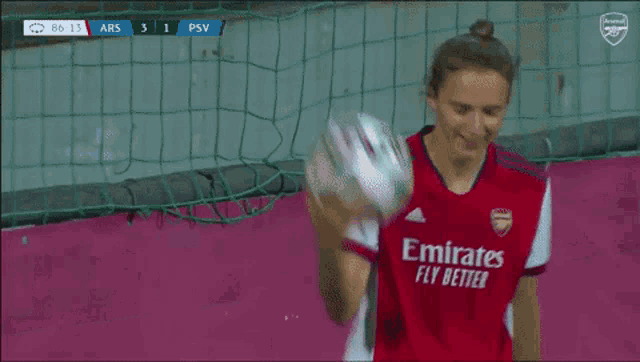 a female soccer player in a red and white uniform kicks the ball