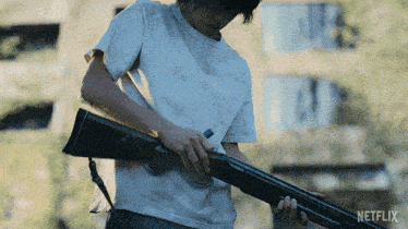 a man in a white shirt is holding a shotgun with a netflix logo in the background