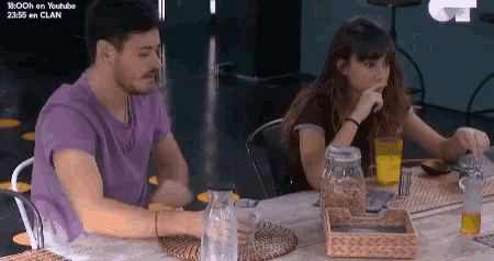 a man and a woman are sitting at a table in front of a screen that says youtube