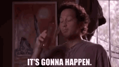 a man is holding a glass of wine and smoking a cigarette while saying `` it 's gonna happen . ''