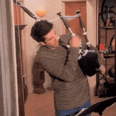 a man is playing a bagpipe in a room
