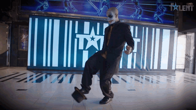 a man is dancing in front of a sign that says the talent