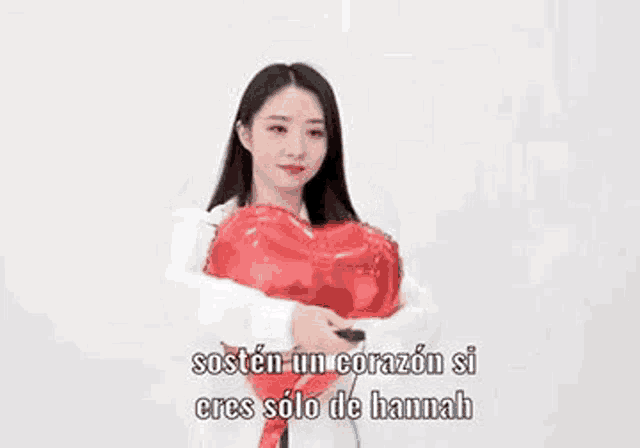 a woman is holding a heart shaped balloon .