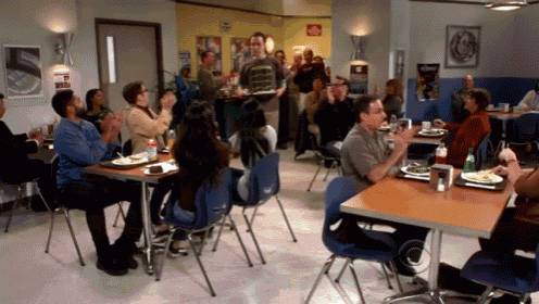 a group of people sit at tables in a restaurant