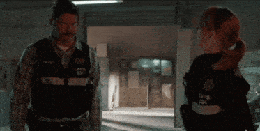 a man and a woman are standing next to each other and the man 's vest says lypd on it