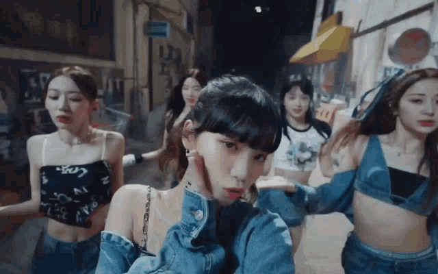 a group of women are dancing in a dark alleyway