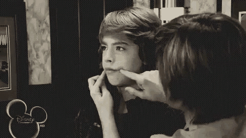a black and white photo of two boys giving the middle finger .