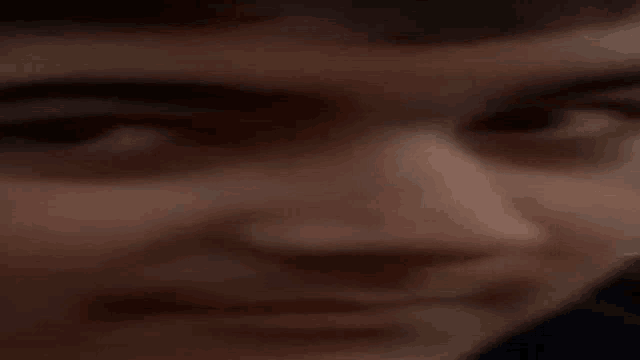 a close up of a person 's face with a blurry background