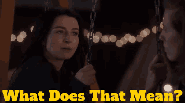 a woman is sitting on a swing with the words what does that mean below her