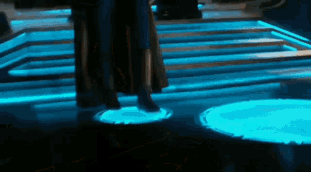 a person is standing on a platform with blue lights