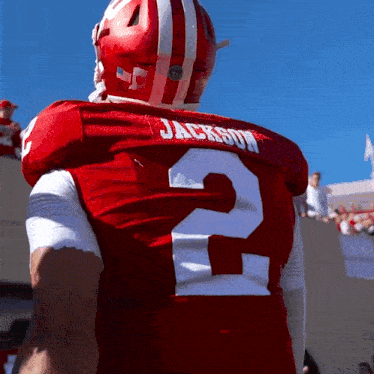a football player wearing a red jersey with the number 2 on the back