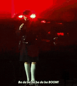 a man in a kilt is standing in front of a red light and says ba da ba da ba da ba boom