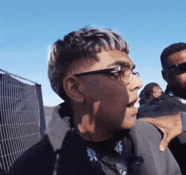 a man wearing glasses has a lanyard around his neck that says ' rugby ' on it