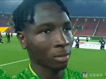 a man in a green and yellow shirt with the letter n on it