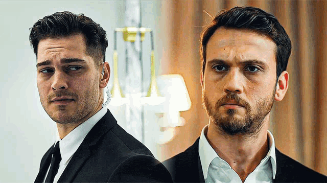 two men in suits are standing next to each other and looking at the camera