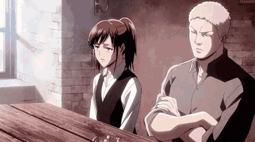 a man and a woman are sitting at a table in a room .