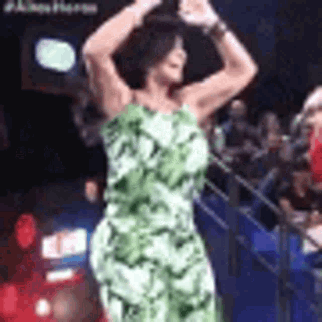 a woman in a green dress is dancing on stage .