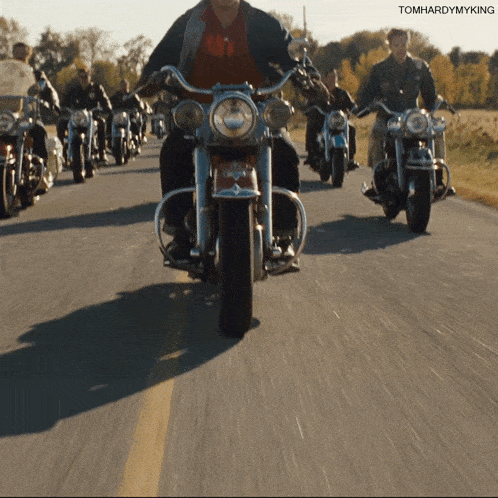 a group of men are riding motorcycles down a road with tomhardymyking written on the bottom