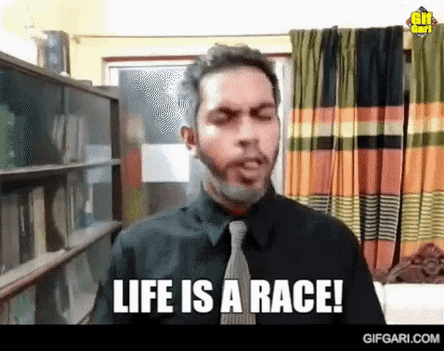 a man with a beard and tie is talking about life is a race .