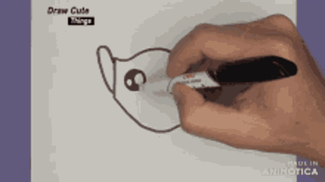 a person is drawing a cat on a piece of paper that says draw cute