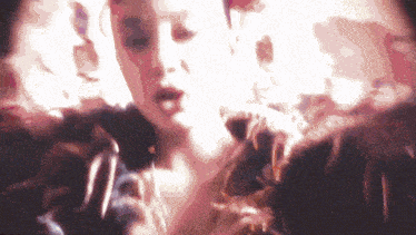 a woman is singing into a microphone in a blurred image