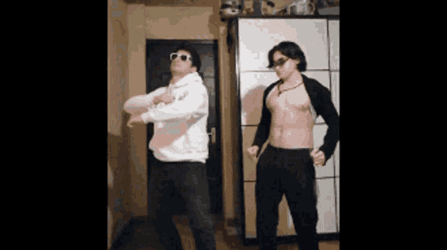 two men are dancing in a room with a door in the background